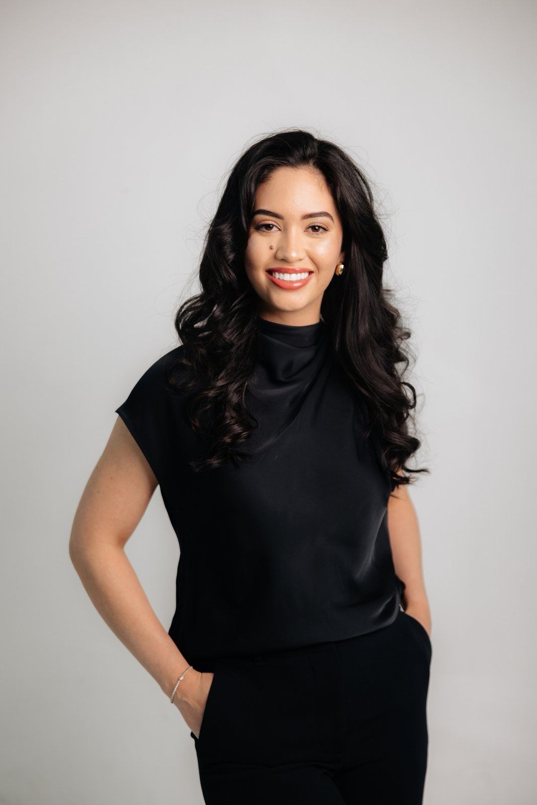 Debbie Cadle smiling in a black top, hands in her pockets